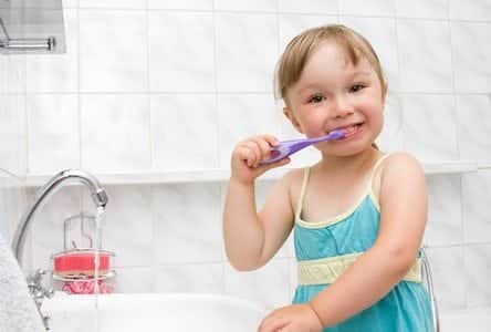 Young girl brushing teeth with skills she learned at Montgomery Pediatric Dentistry in Princeton, NJ.