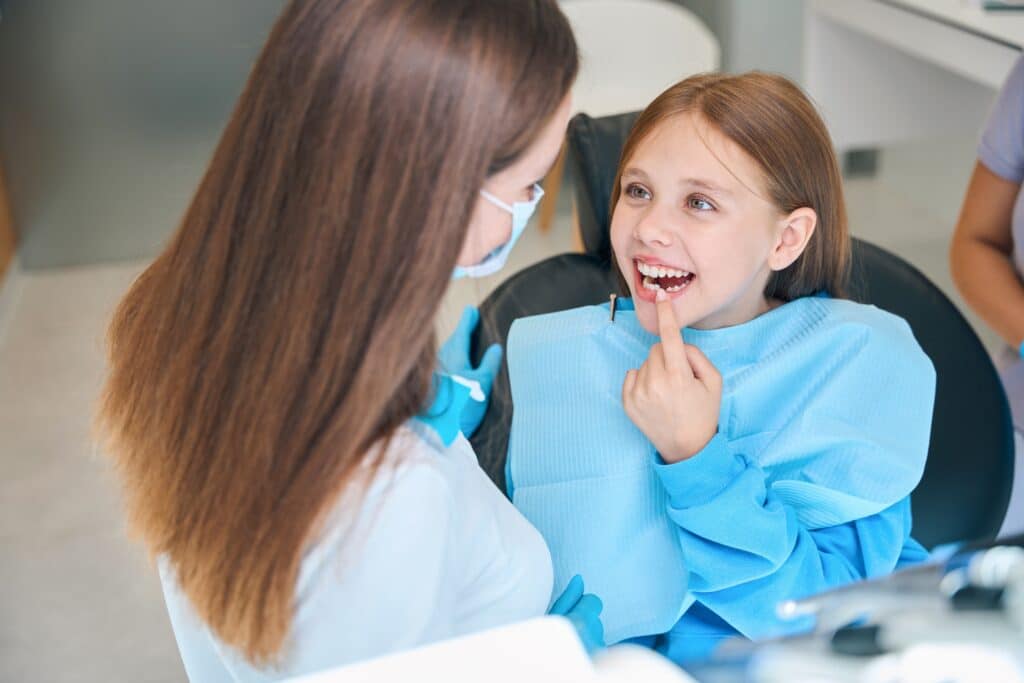 Emergency pediatric dentist comforting a young child with tooth pain at a dental clinic